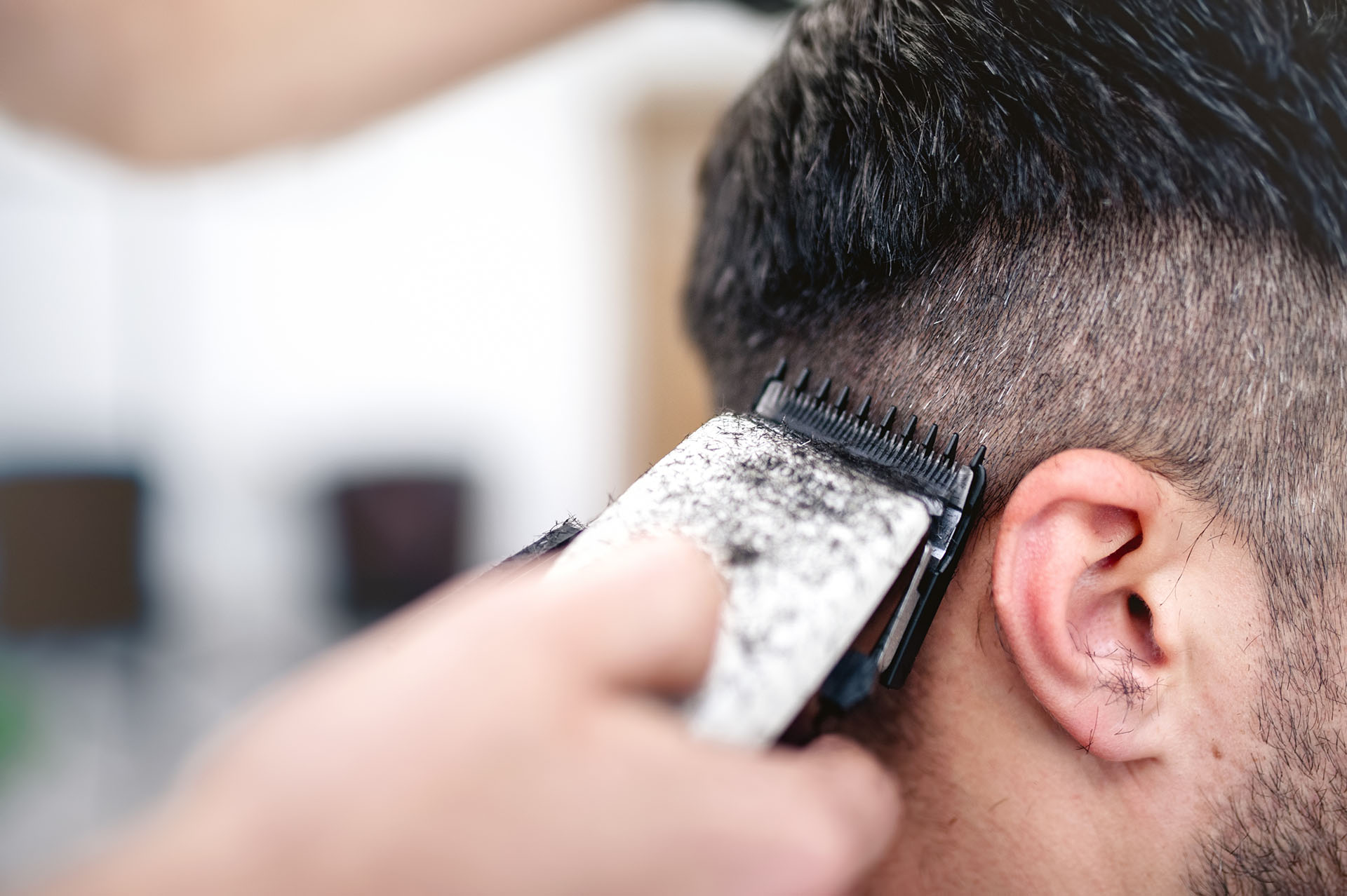 Barber giving haircut with sharp clipper